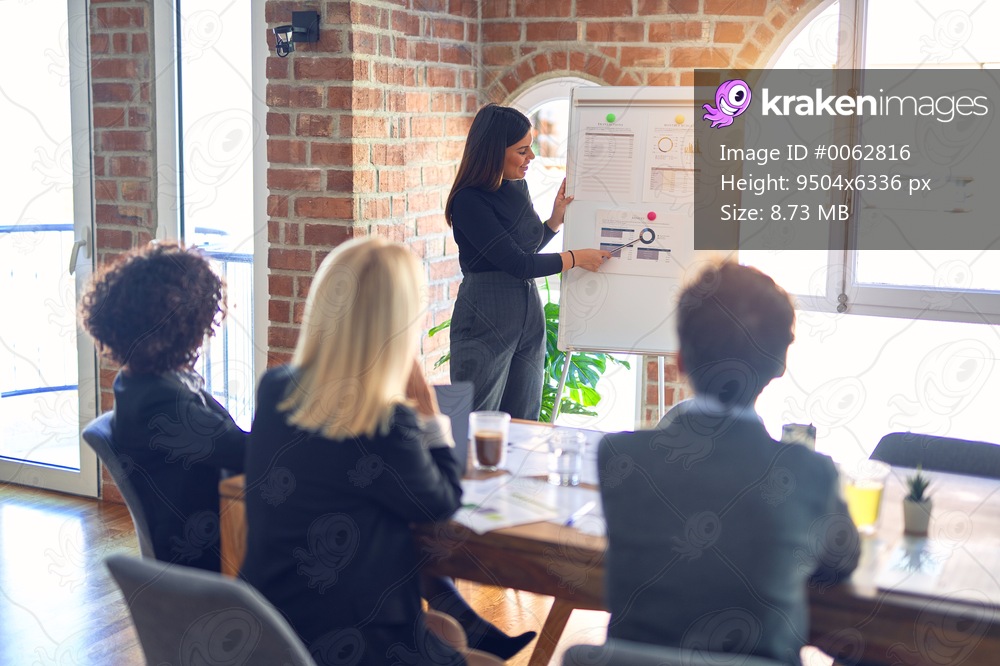 Group of business workers working together in a meeting. One of them making presentation to colleagues at the office