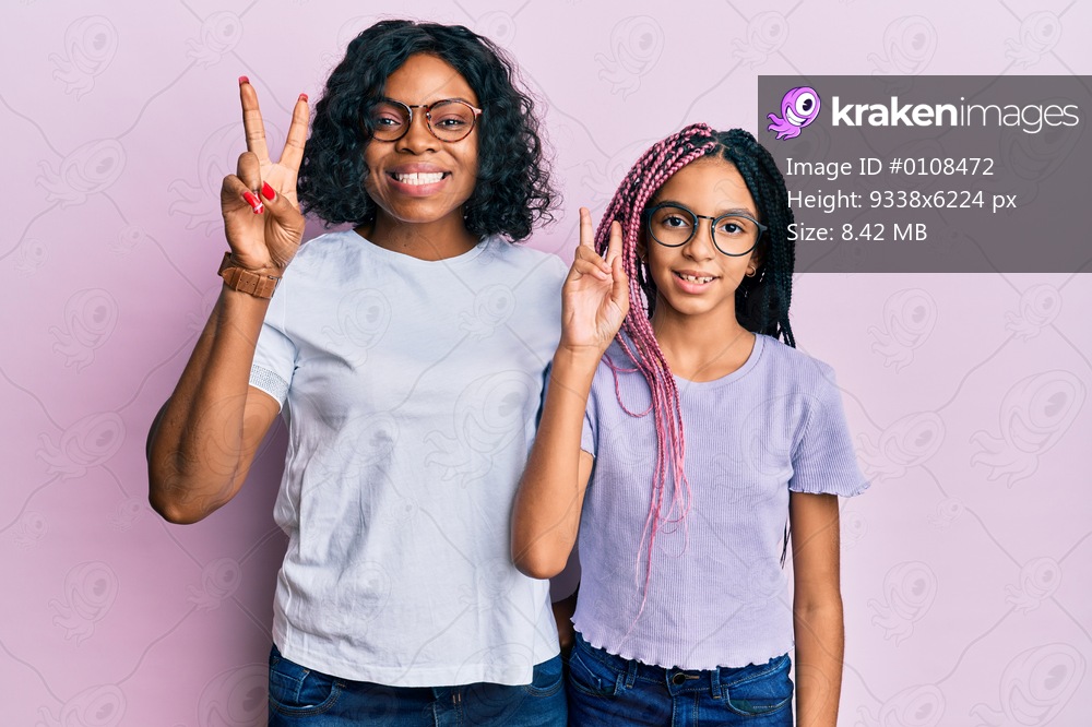 Beautiful african american mother and daughter wearing casual clothes and glasses smiling looking to the camera showing fingers doing victory sign. number two. 