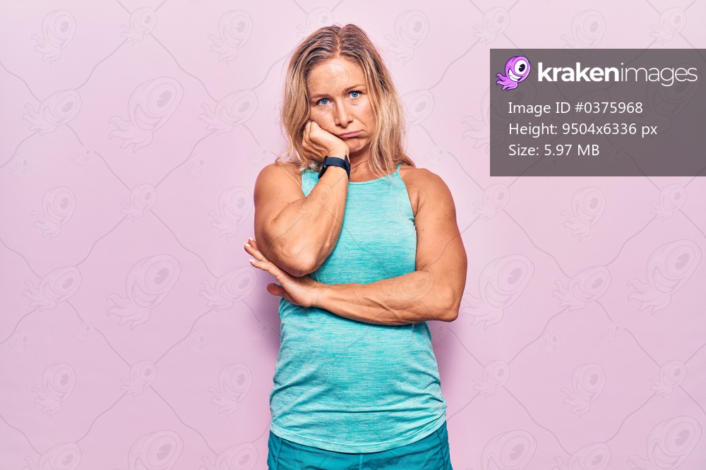 Middle age caucasian blonde woman wearing sports clothes over pink background thinking looking tired and bored with depression problems with crossed arms. 