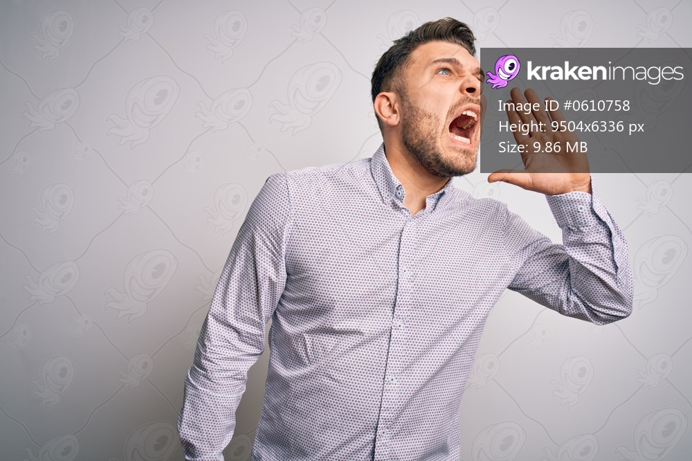 Young business man with blue eyes standing over isolated background shouting and screaming loud to side with hand on mouth. Communication concept.