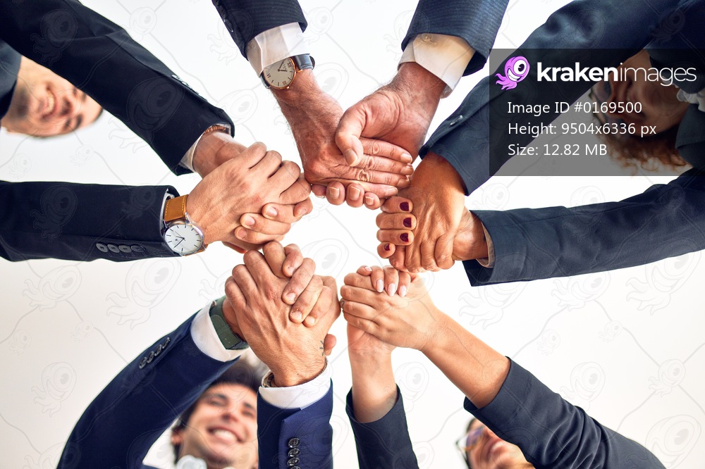Group of business workers smiling happy and confident. Standing on a circle with smile on face doing symbol with hands and arms together at the office.