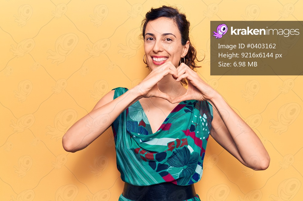 Young beautiful hispanic woman wearing casual clothes smiling in love doing heart symbol shape with hands. romantic concept. 