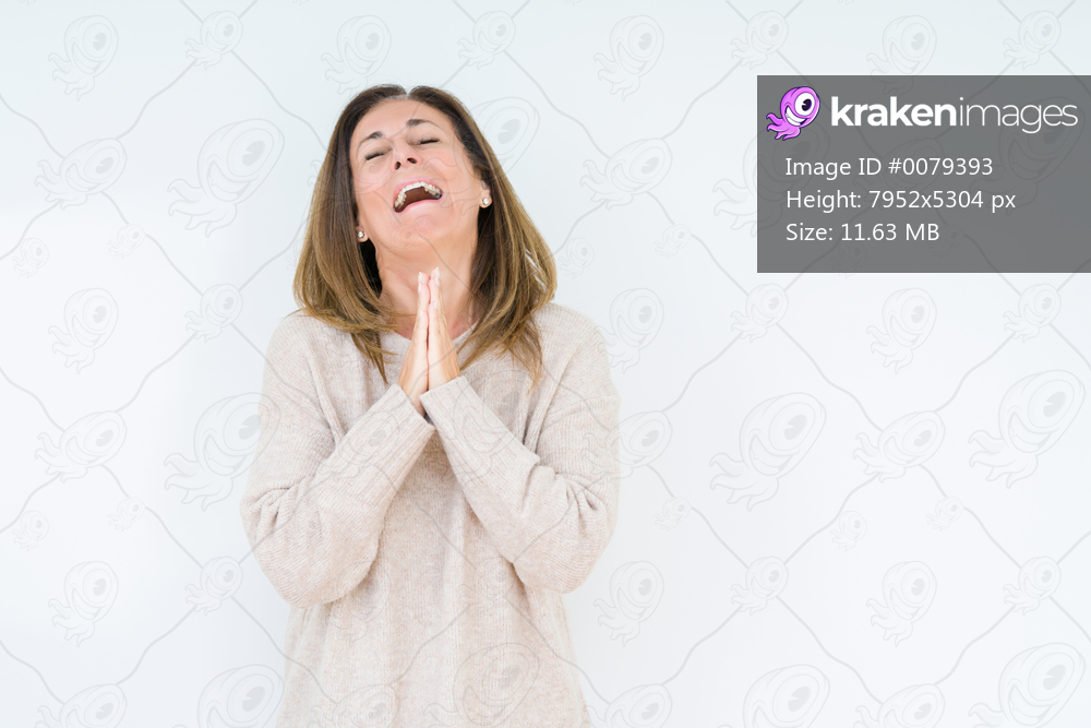 Beautiful middle age woman over isolated background begging and praying with hands together with hope expression on face very emotional and worried. Asking for forgiveness. Religion concept.
