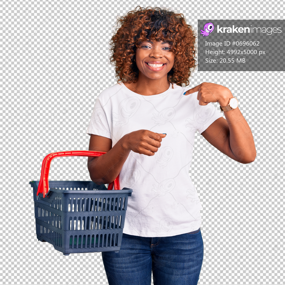 Young african american woman holding supermarket shopping basket pointing finger to one self smiling happy and proud