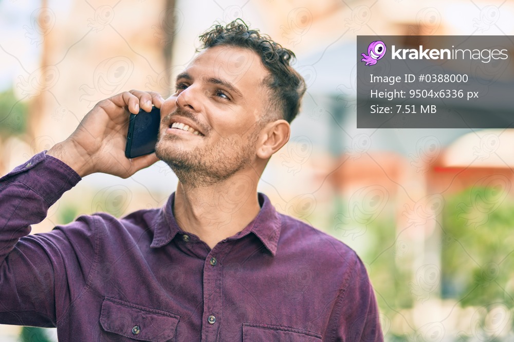 Young hispanic man smiling happy talking on the smartphone at the city.