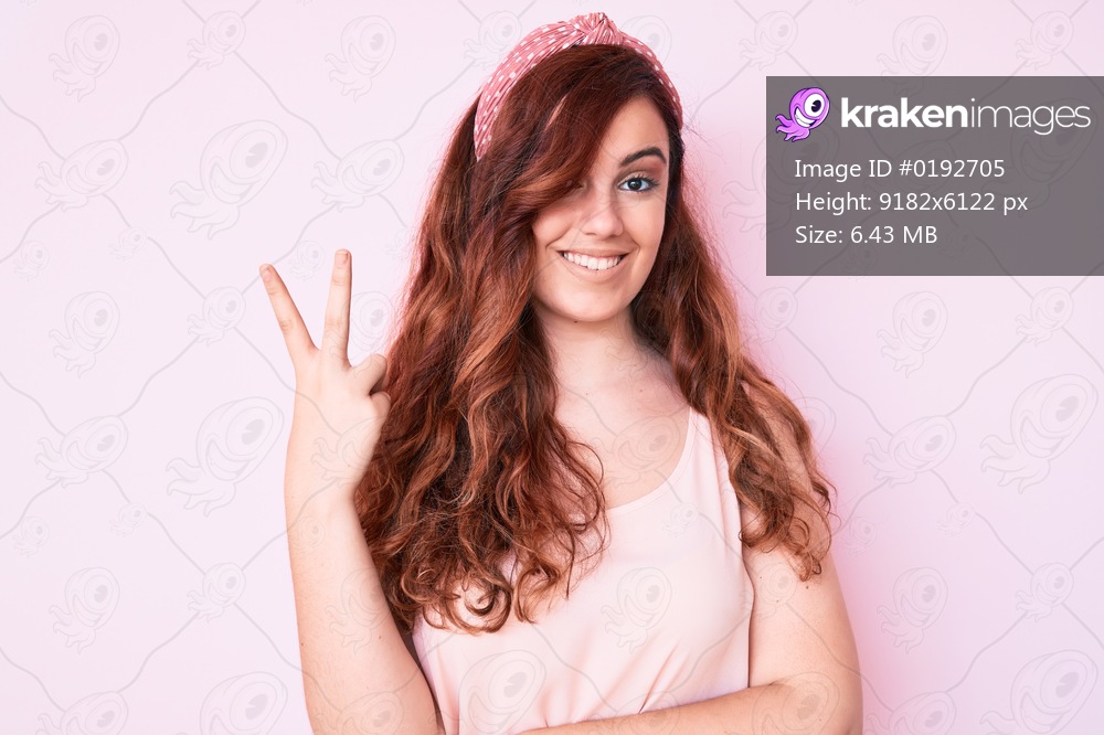 Young beautiful woman wearing casual clothes smiling with happy face winking at the camera doing victory sign with fingers. number two. 