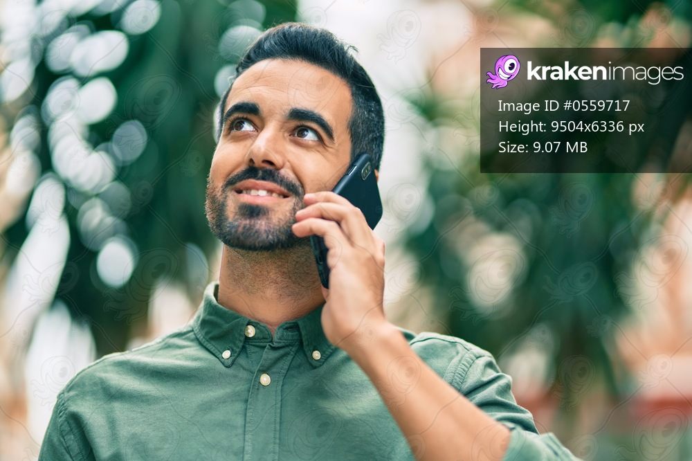 Young hispanic man smiling happy talking on the smartphone at the city.