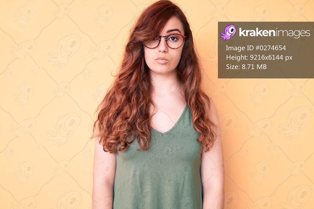 Young beautiful woman wearing casual clothes and glasses with serious expression on face. simple and natural looking at the camera. 