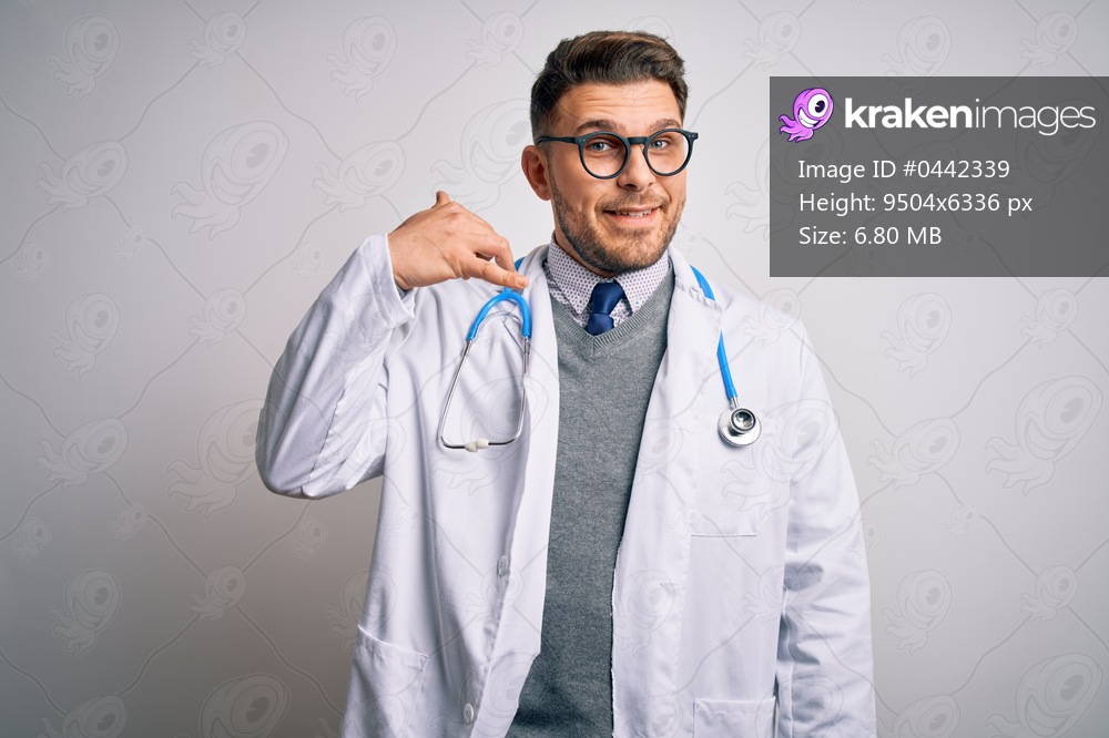 Young doctor man with blue eyes wearing medical coat and stethoscope over isolated background smiling doing phone gesture with hand and fingers like talking on the telephone. Communicating concepts.