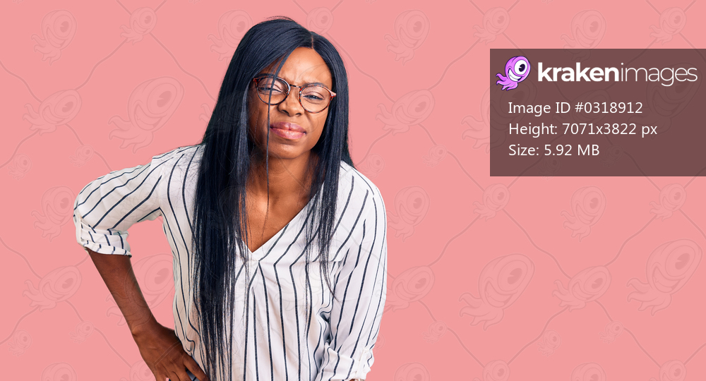 Young african american woman wearing casual clothes and glasses suffering of backache, touching back with hand, muscular pain 