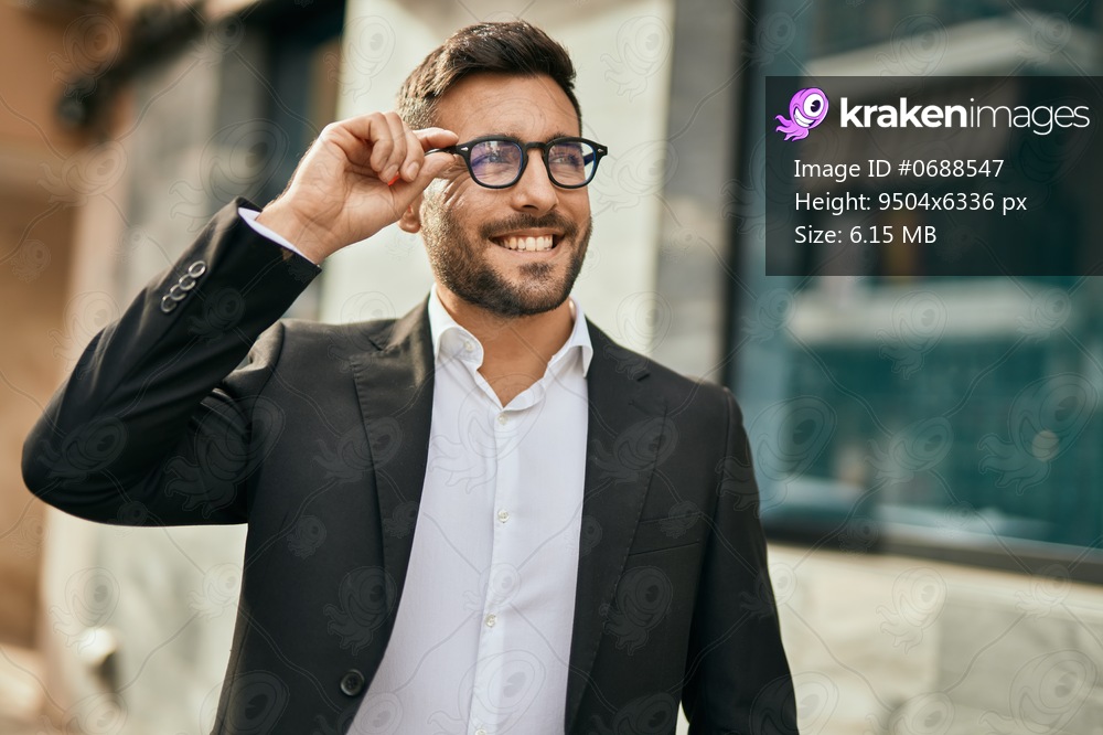 Young hispanic businessman smiling happy standing at the city.
