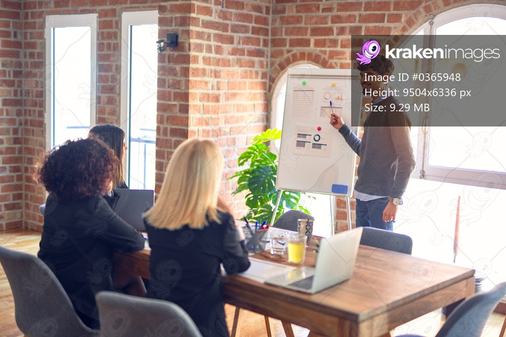 Group of business workers working together in a meeting. One of them making presentation to colleagues at the office