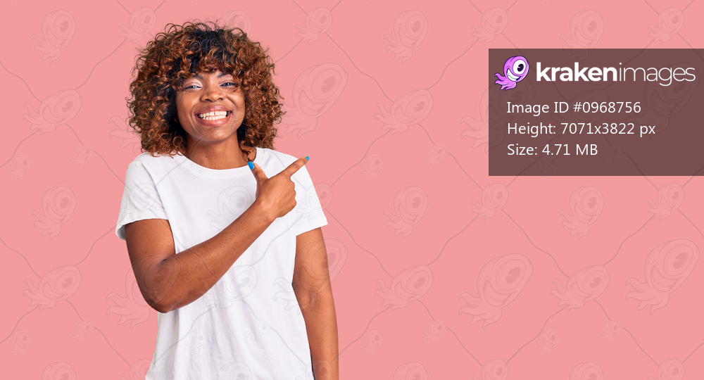 Young african american woman wearing casual white tshirt cheerful with a smile of face pointing with hand and finger up to the side with happy and natural expression on face 