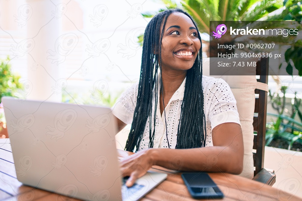 Young african american woman smiling happy working using laptop at terrace