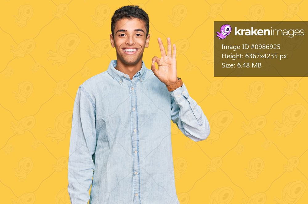 Young handsome african american man wearing casual clothes smiling positive doing ok sign with hand and fingers. successful expression. 