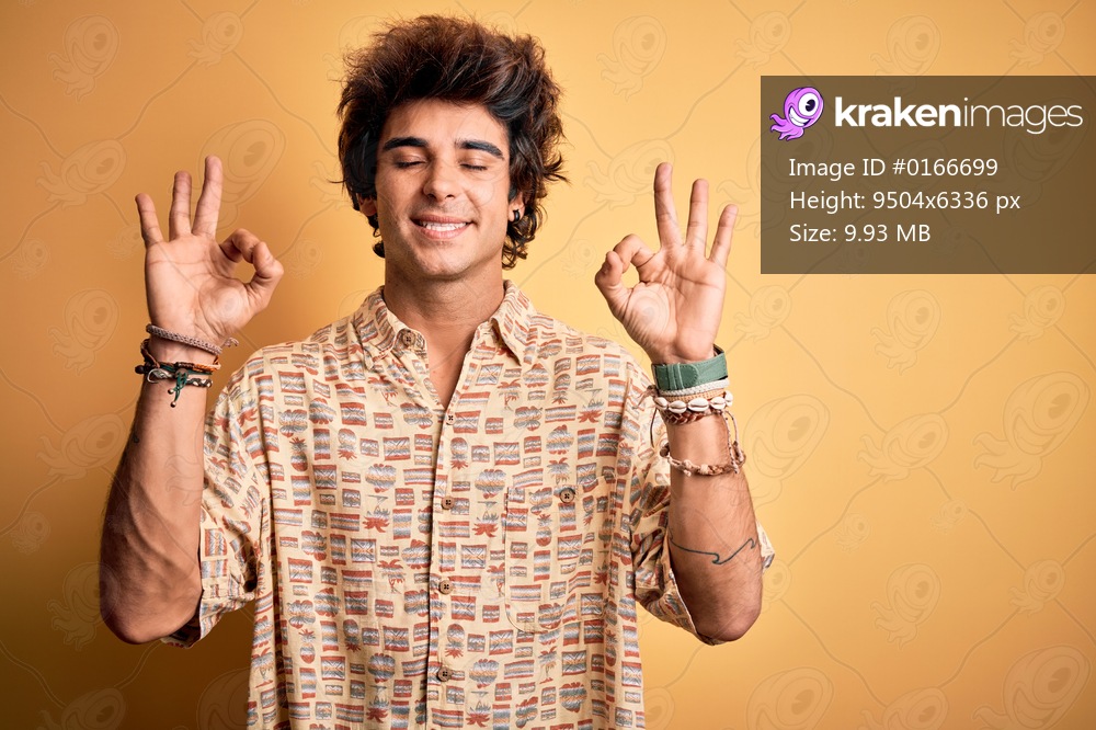 Young handsome man on vacation wearing summer shirt over isolated yellow background relax and smiling with eyes closed doing meditation gesture with fingers. Yoga concept.