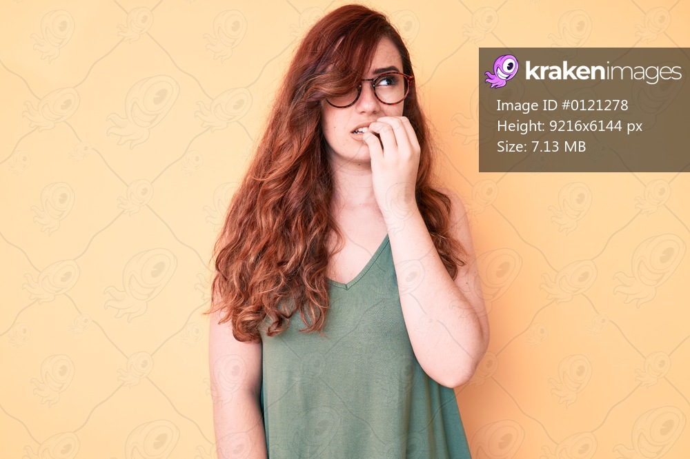 Young beautiful woman wearing casual clothes and glasses looking stressed and nervous with hands on mouth biting nails. anxiety problem. 
