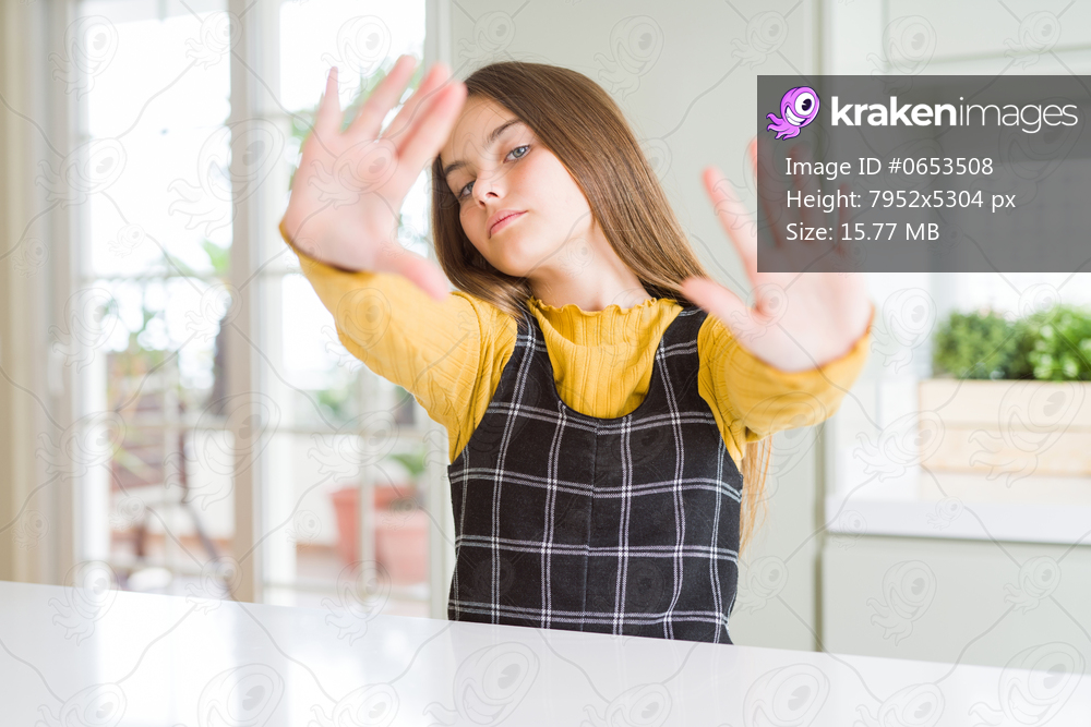 Young beautiful blonde kid girl wearing casual yellow sweater at home doing frame using hands palms and fingers, camera perspective