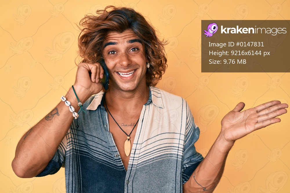 Young hispanic man having conversation talking on the smartphone celebrating achievement with happy smile and winner expression with raised hand 