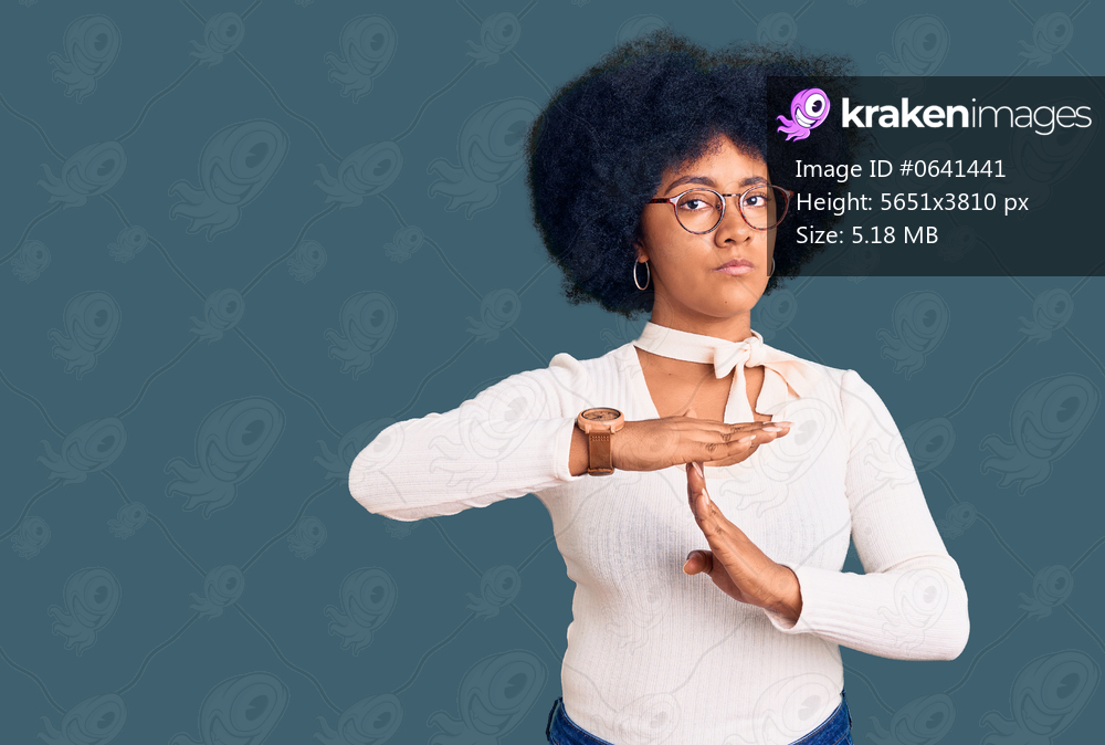Young african american girl wearing casual clothes and glasses doing time out gesture with hands, frustrated and serious face 