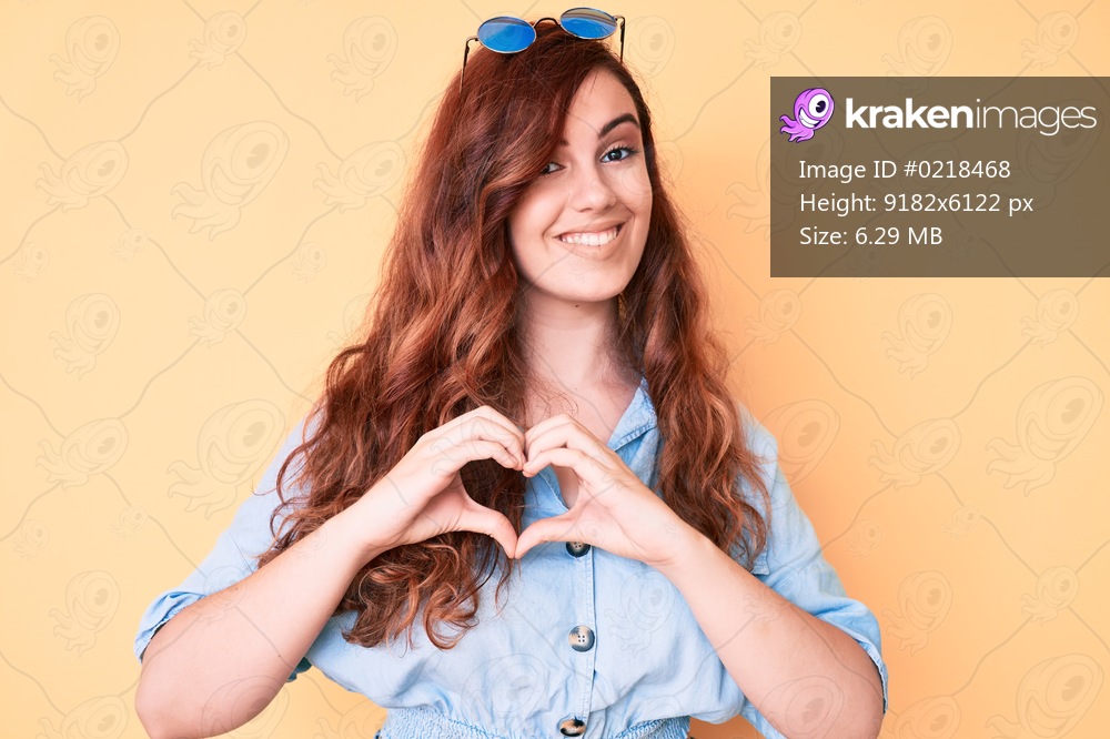 Young beautiful woman wearing casual clothes and sunglasses smiling in love showing heart symbol and shape with hands. romantic concept. 
