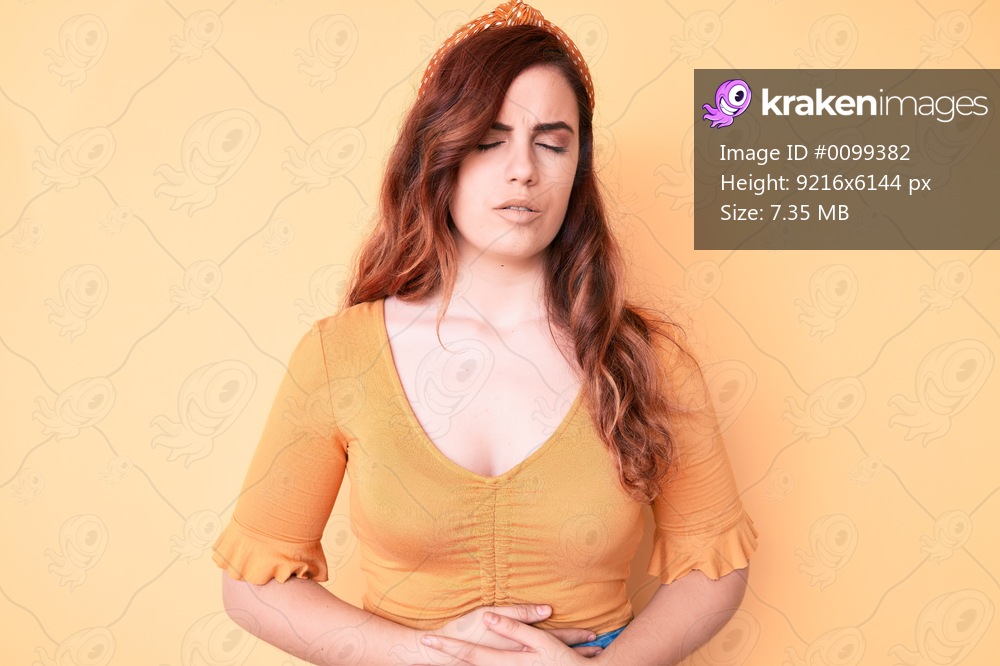Young beautiful woman wearing casual clothes with hand on stomach because indigestion, painful illness feeling unwell. ache concept. 