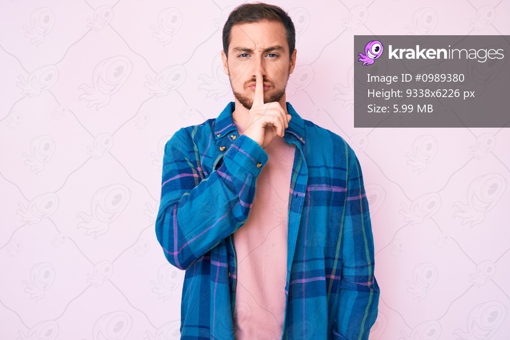 Young handsome man wearing casual clothes asking to be quiet with finger on lips. silence and secret concept. 