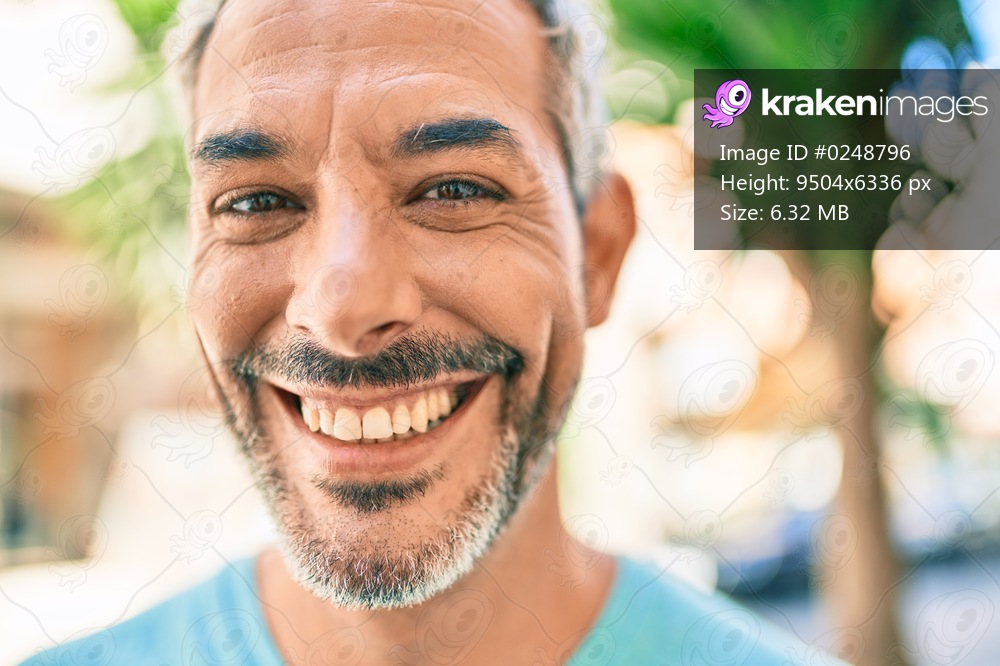 Middle age grey-haired man smiling happy walking at street of city.