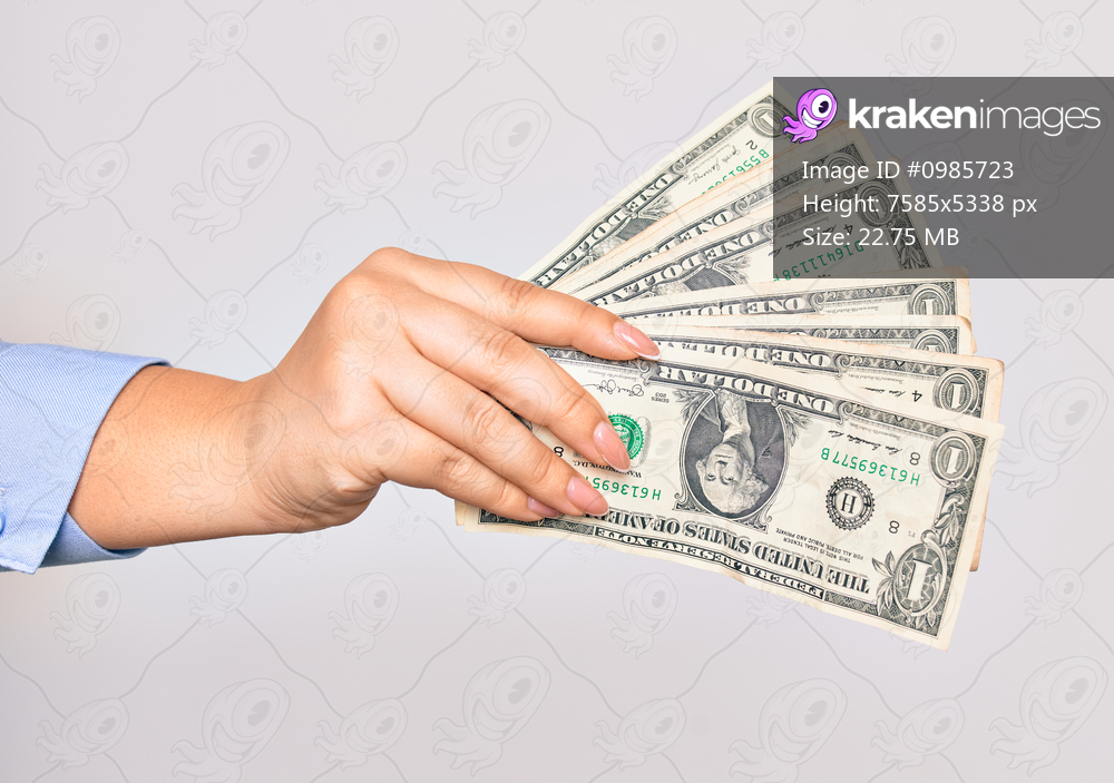 Hand of caucasian young woman holding bunch of dollars banknote over isolated white background