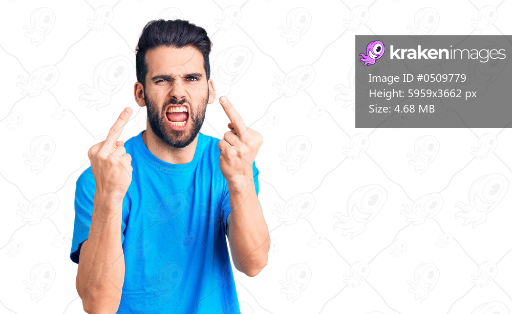 Young handsome man with beard wearing casual t-shirt showing middle finger doing fuck you bad expression, provocation and rude attitude. screaming excited 