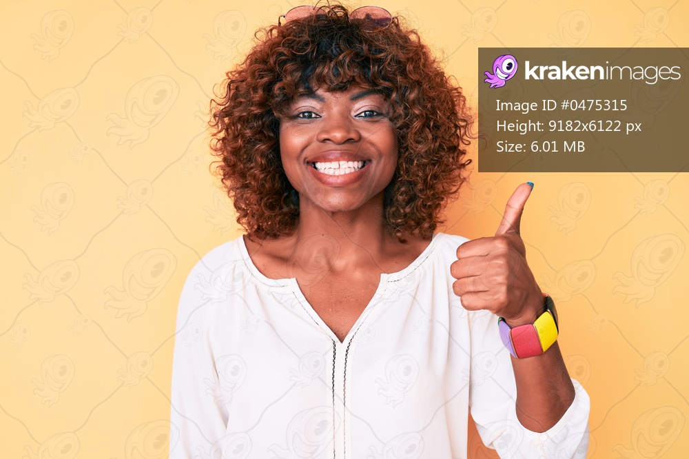 Young african american woman wearing casual clothes smiling happy and positive, thumb up doing excellent and approval sign 