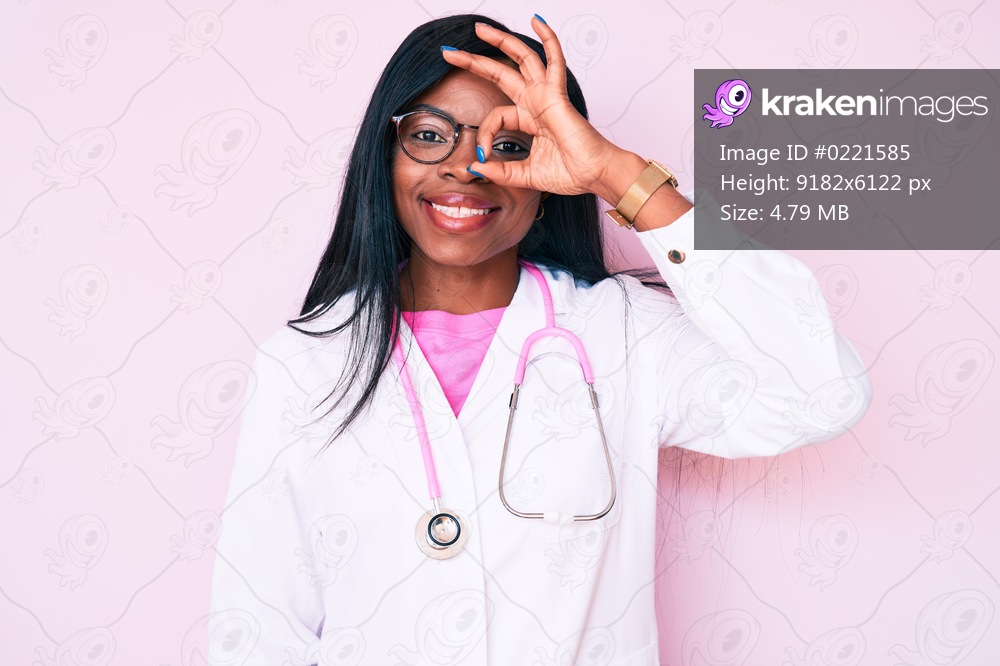 Young african american woman wearing doctor stethoscope smiling happy doing ok sign with hand on eye looking through fingers 