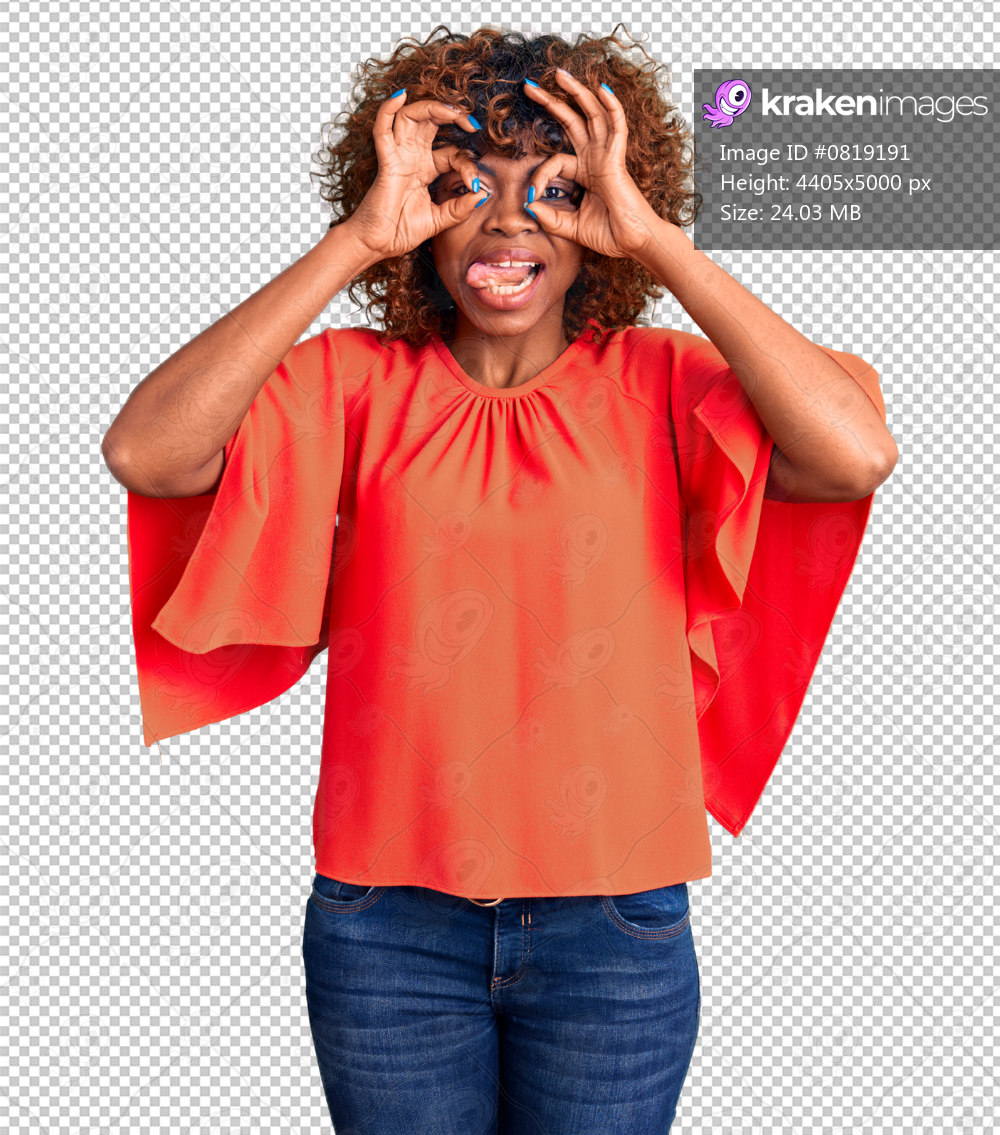 Young african american woman wearing casual clothes doing ok gesture like binoculars sticking tongue out, eyes looking through fingers. crazy expression.