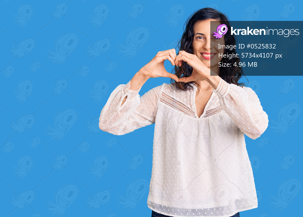 Young beautiful hispanic woman wearing casual clothes smiling in love showing heart symbol and shape with hands. romantic concept. 