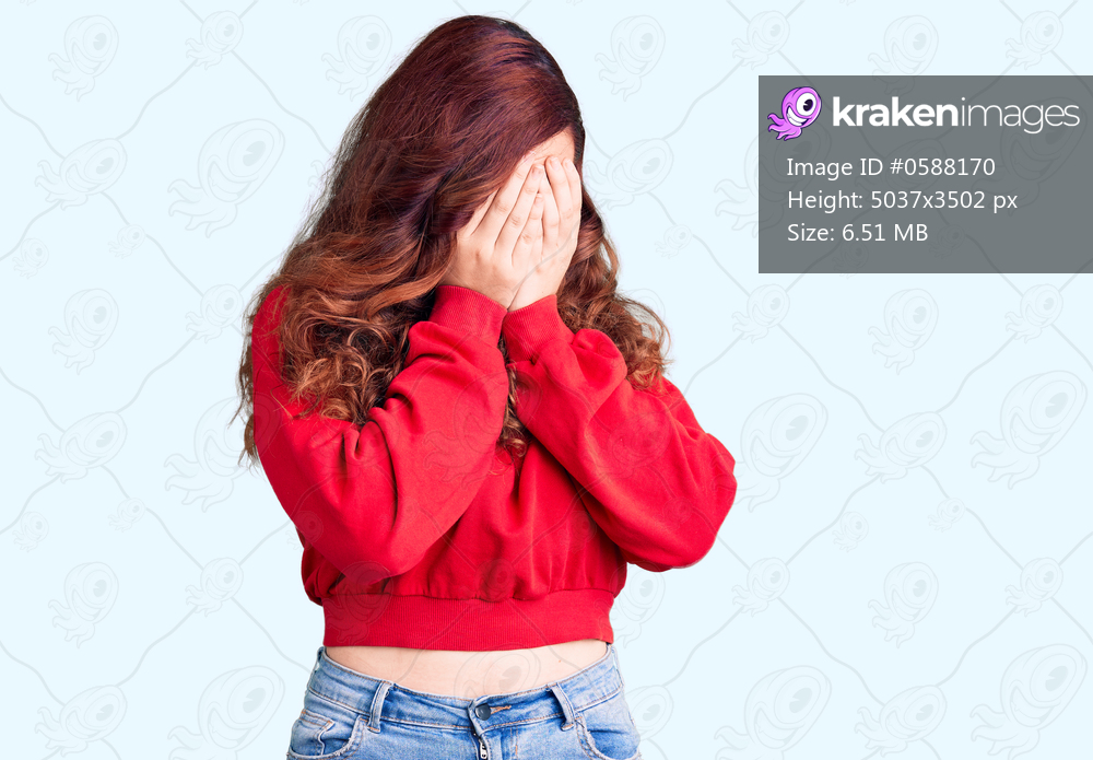 Young beautiful woman wearing casual winter sweater with sad expression covering face with hands while crying. depression concept. 
