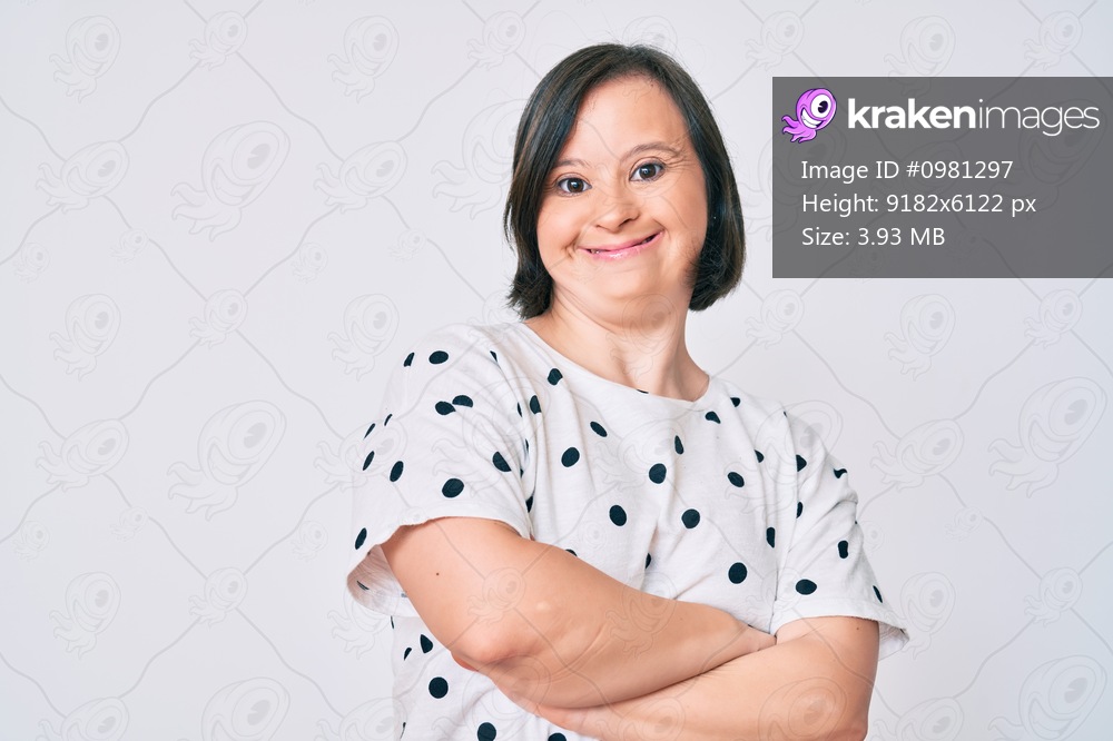 Brunette woman with down syndrome wearing casual clothes happy face smiling with crossed arms looking at the camera. positive person. 