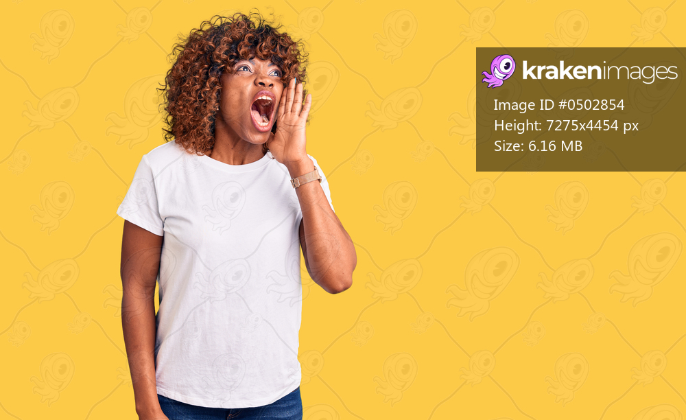 Young african american woman wearing casual white tshirt shouting and screaming loud to side with hand on mouth. communication concept. 