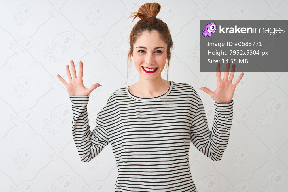 Redhead woman wearing navy striped t-shirt standing over isolated white background showing and pointing up with fingers number ten while smiling confident and happy.