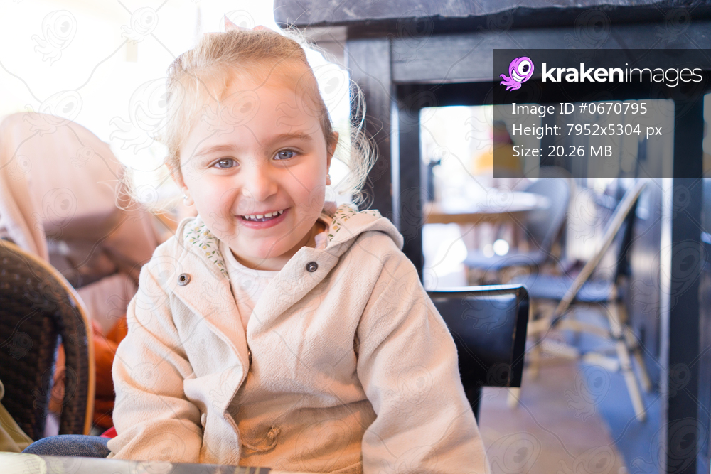 Beautiful toddler child girl sitting on baby highchair laughing