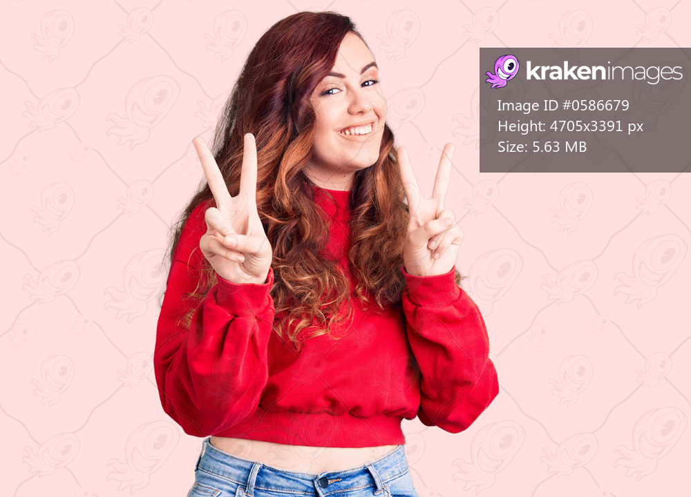 Young beautiful woman wearing casual winter sweater smiling looking to the camera showing fingers doing victory sign. number two. 