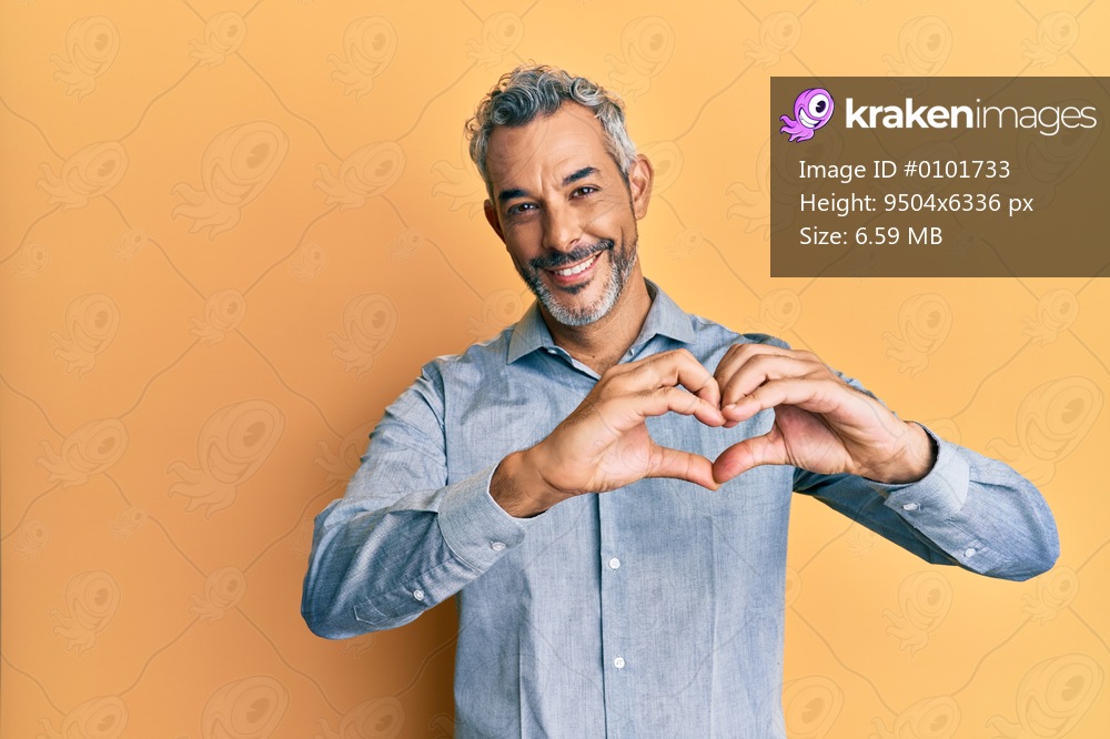 Middle age grey-haired man wearing casual clothes smiling in love showing heart symbol and shape with hands. romantic concept. 