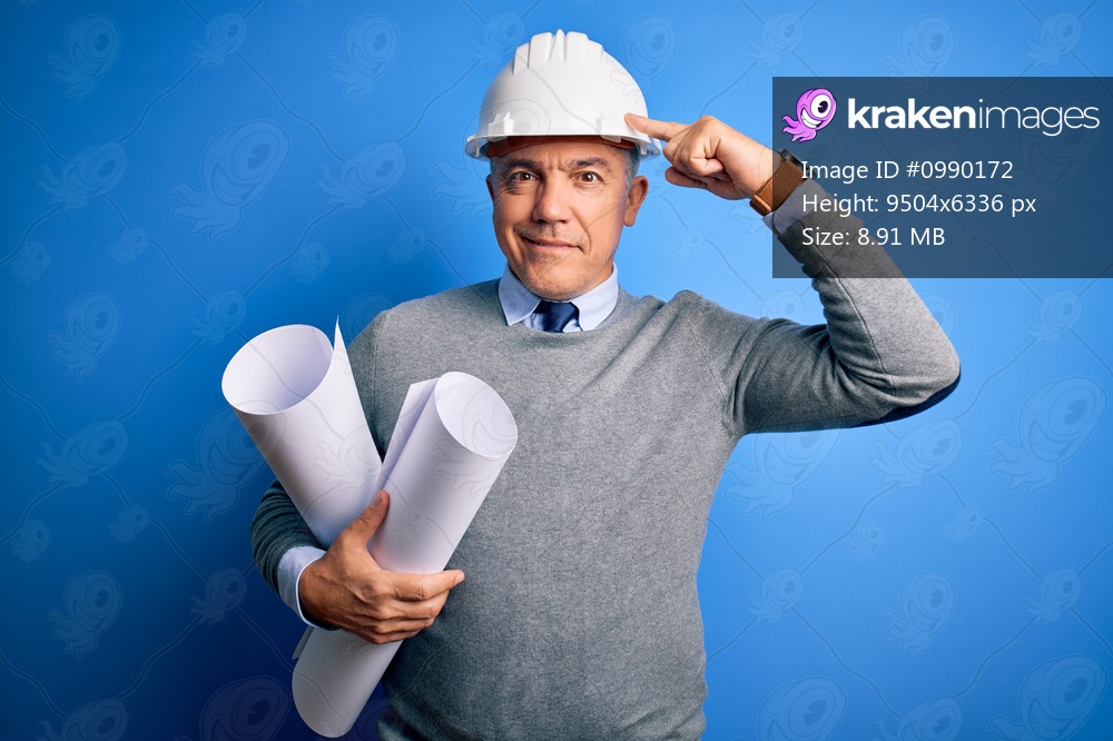 Middle age handsome grey-haired architect man wearing safety helmet holding blueprints Smiling pointing to head with one finger, great idea or thought, good memory