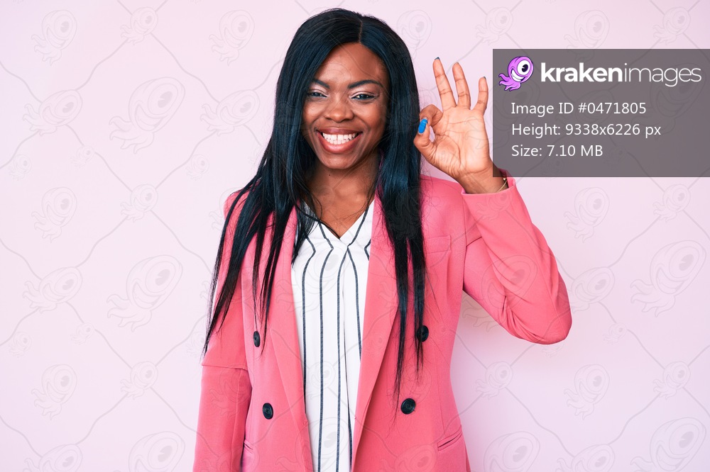 Young african american woman wearing business clothes smiling positive doing ok sign with hand and fingers. successful expression. 
