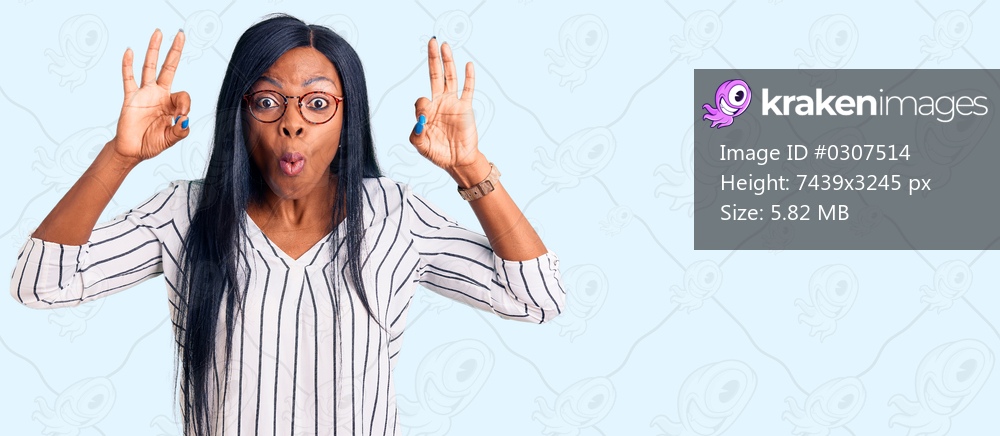 Young african american woman wearing casual clothes and glasses looking surprised and shocked doing ok approval symbol with fingers. crazy expression 