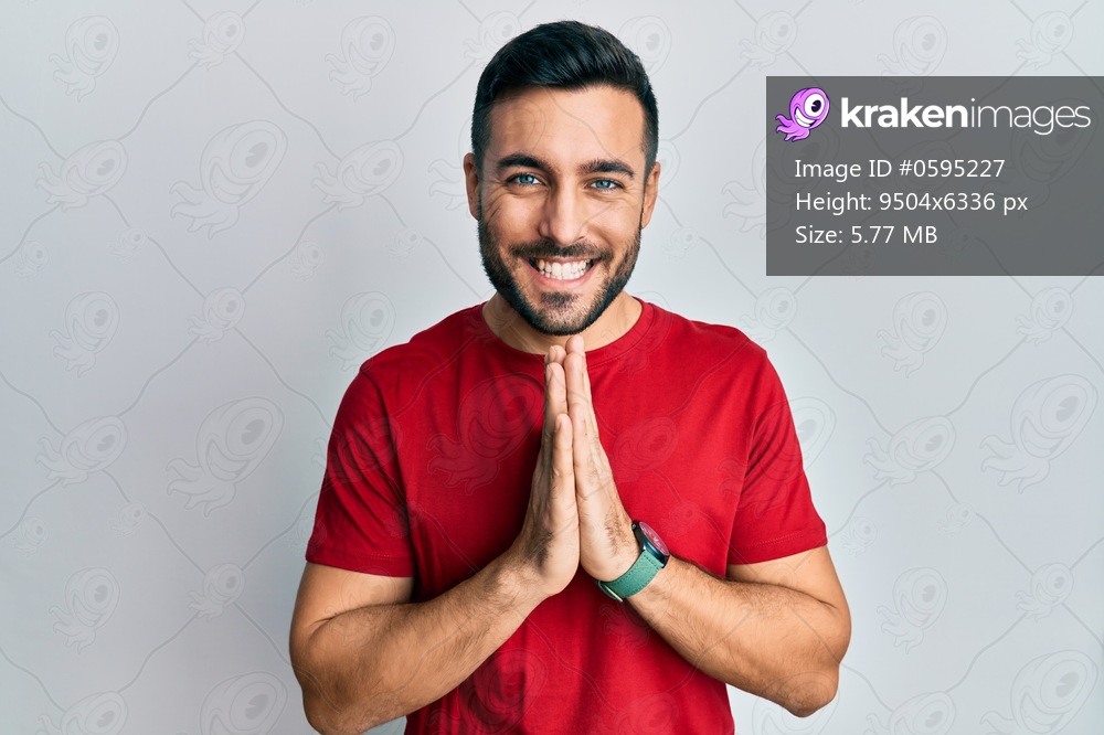 Young hispanic man wearing casual clothes praying with hands together asking for forgiveness smiling confident. 