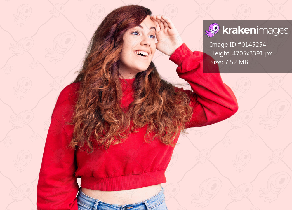 Young beautiful woman wearing casual winter sweater very happy and smiling looking far away with hand over head. searching concept. 