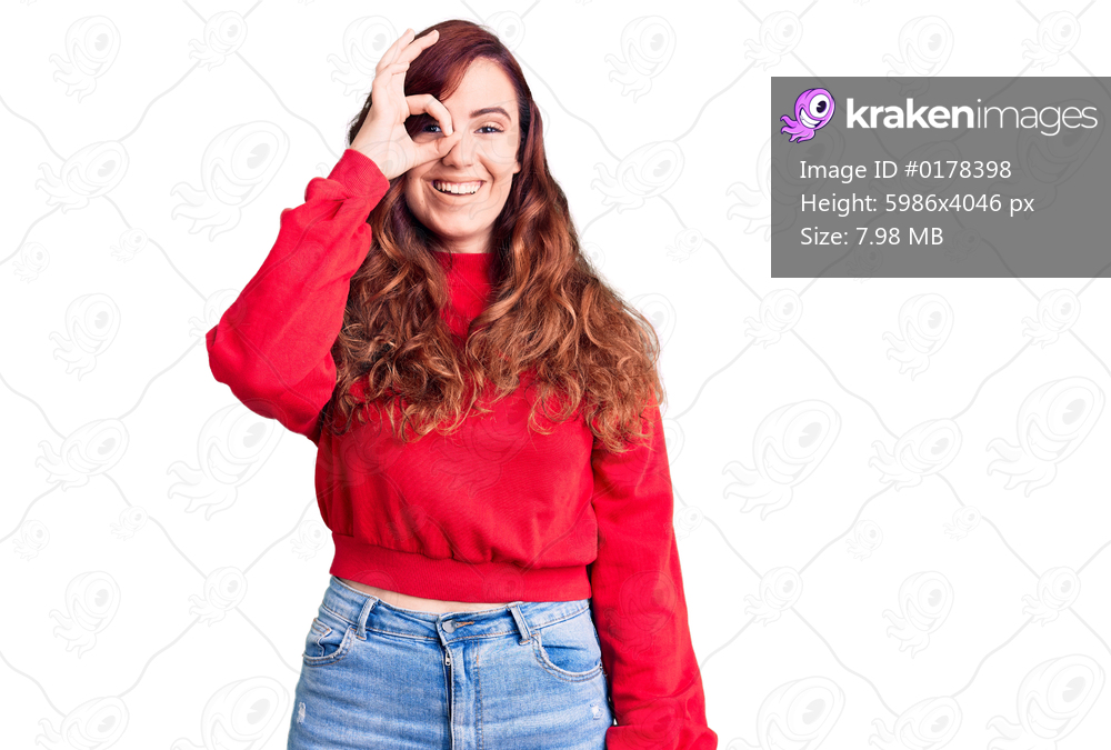 Young beautiful woman wearing casual winter sweater doing ok gesture with hand smiling, eye looking through fingers with happy face. 