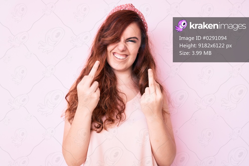Young beautiful woman wearing casual clothes showing middle finger doing fuck you bad expression, provocation and rude attitude. screaming excited 