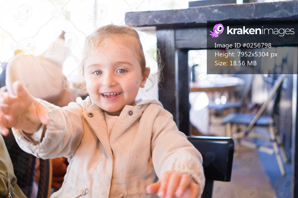 Beautiful toddler child girl sitting on baby highchair laughing