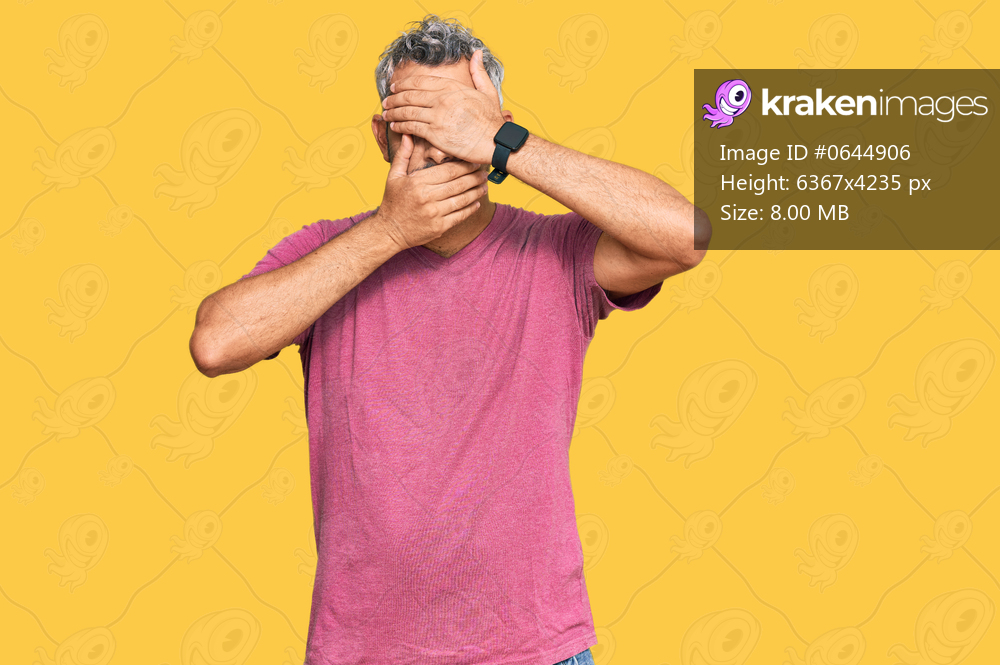Middle age grey-haired man wearing casual clothes covering eyes and mouth with hands, surprised and shocked. hiding emotion 